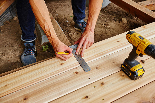 Handwerker verlegt Holzterrasse